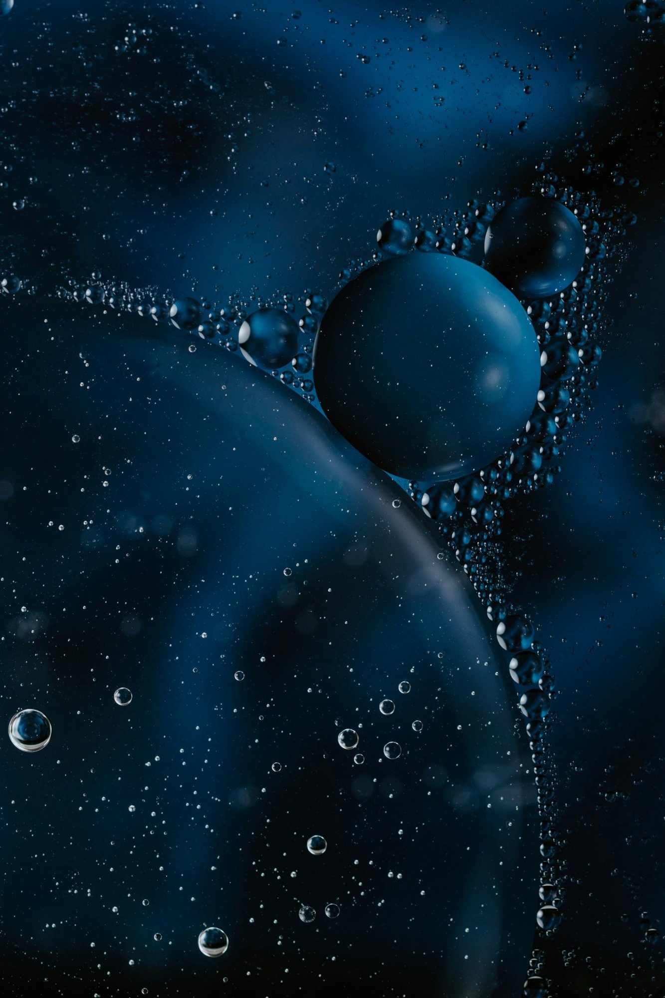 Bubbles drifting through dark blue water