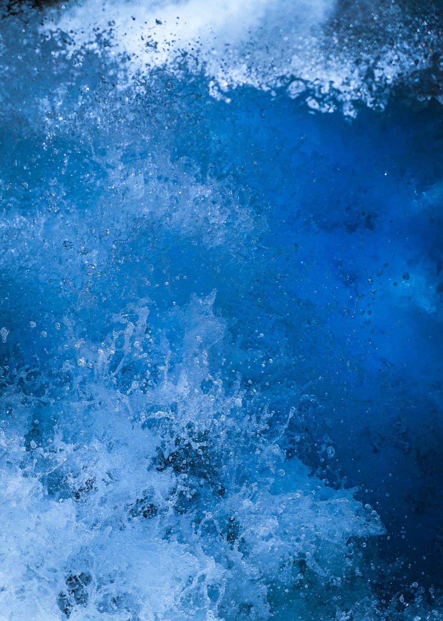 Close-up of a breaking wave in deep blue