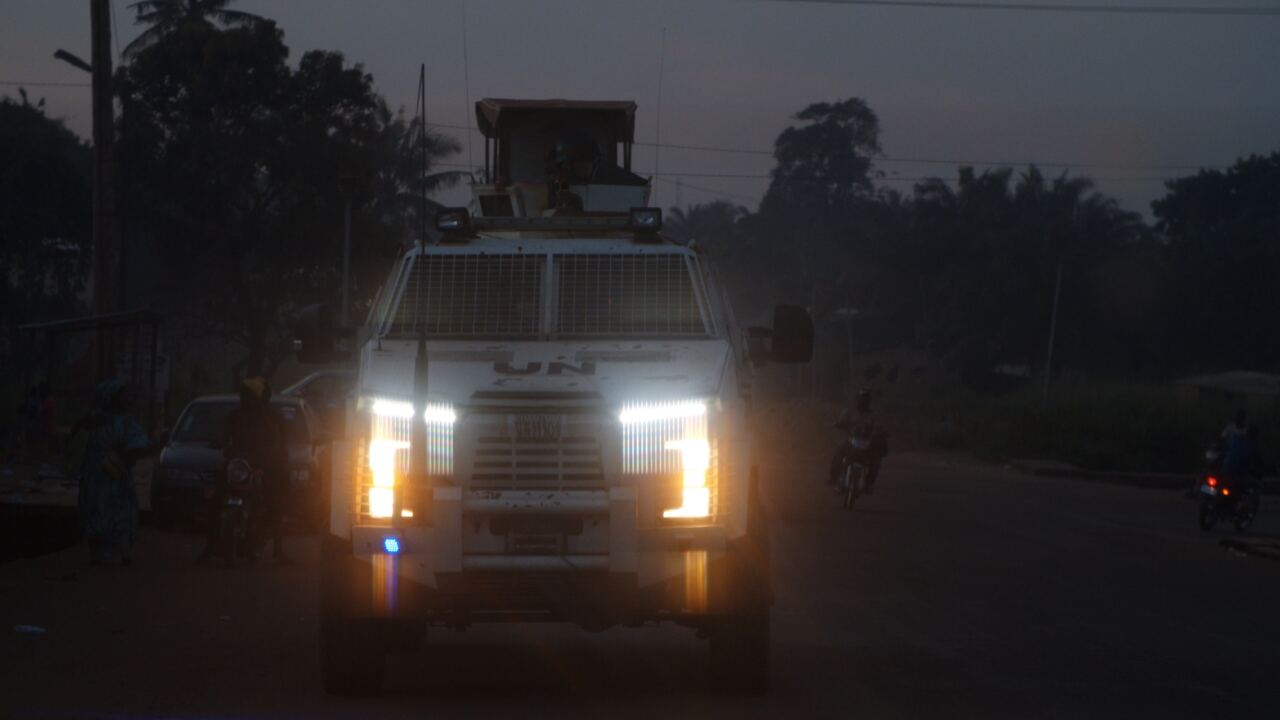 A UN armoured vehicle with headlights on at night