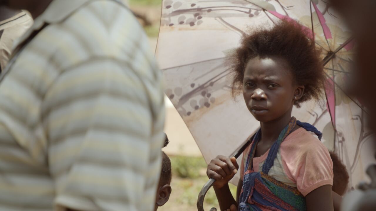 A young girl looking towards the camera in a crowd