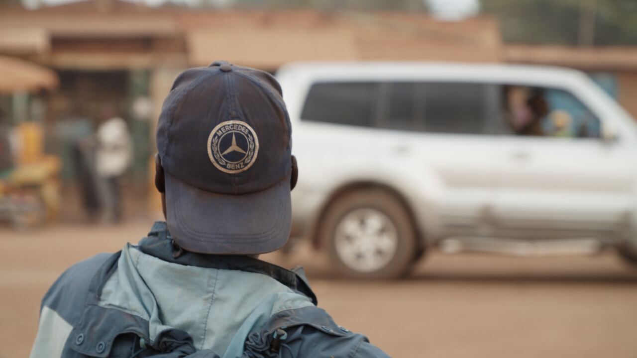 A man watching traffic from the roadside