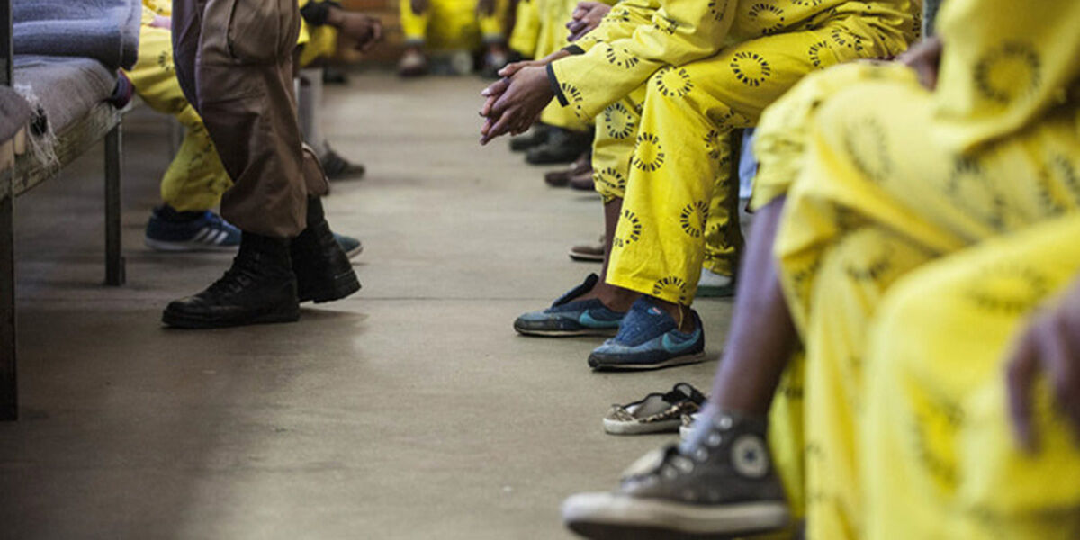 Inmates in yellow uniforms seated in a row, from a Sonke story on prison overcrowding