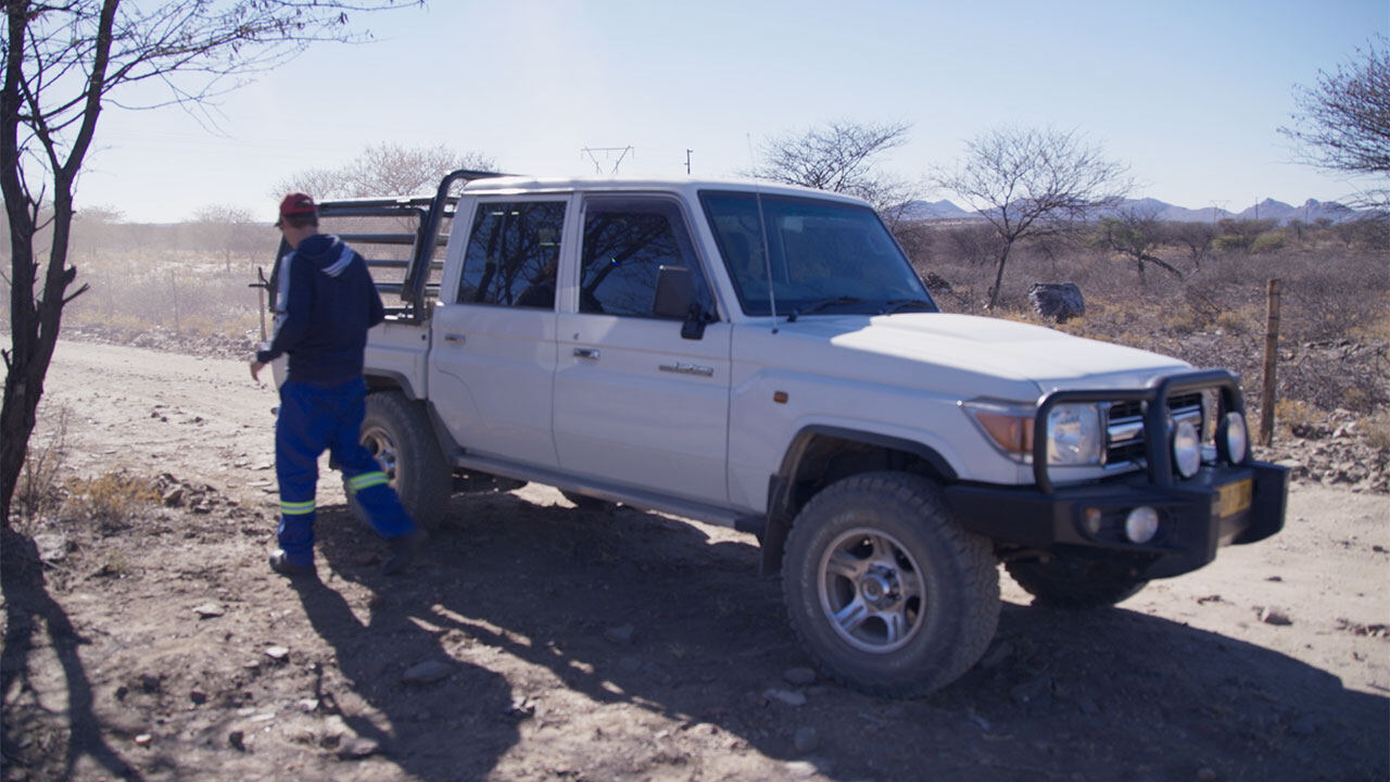 An auditor stepping out of a vehicle on a farm road